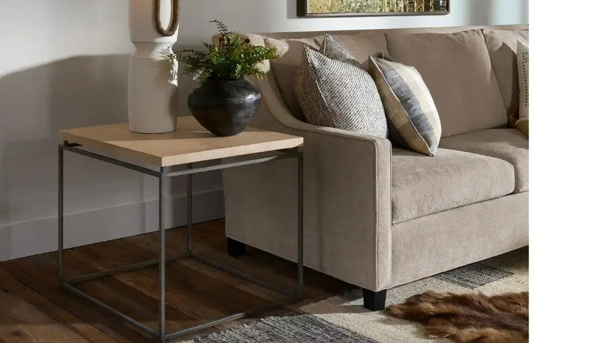Natural oak end table styled beside a neutral sofa with a lamp and vase
