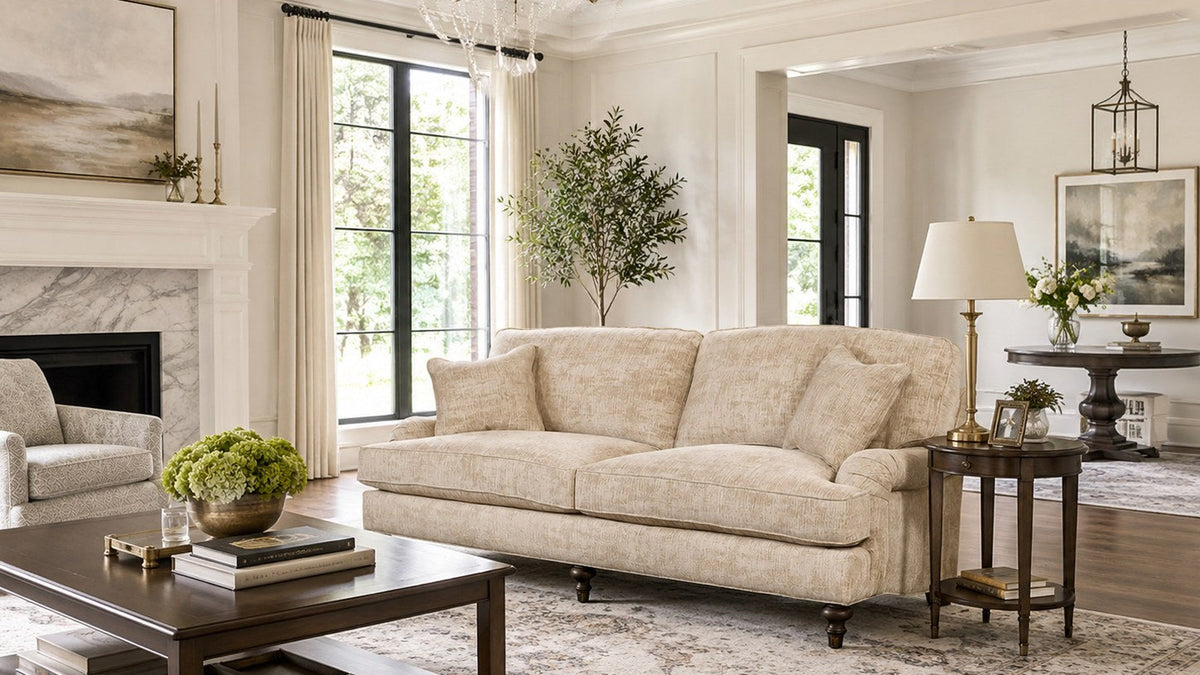 Neutral English roll-arm sofa and chair styled in a bright traditional living room