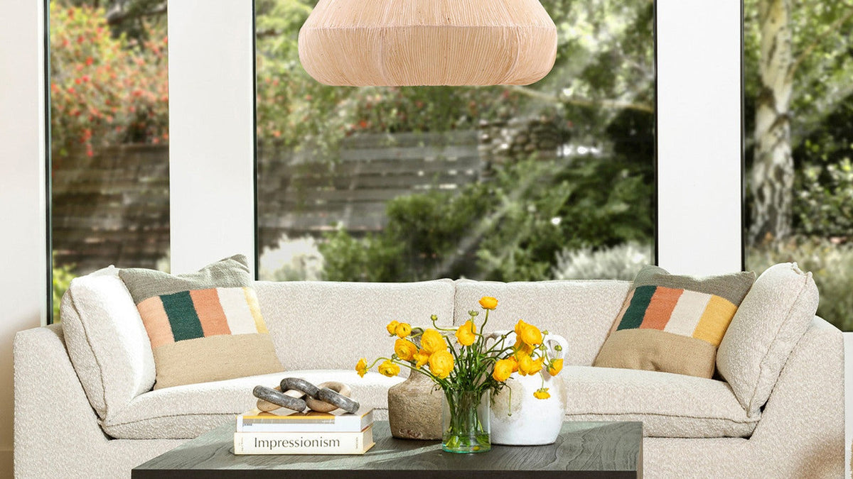 Cream sofa styled with colorful geometric throw pillows in a bright living room