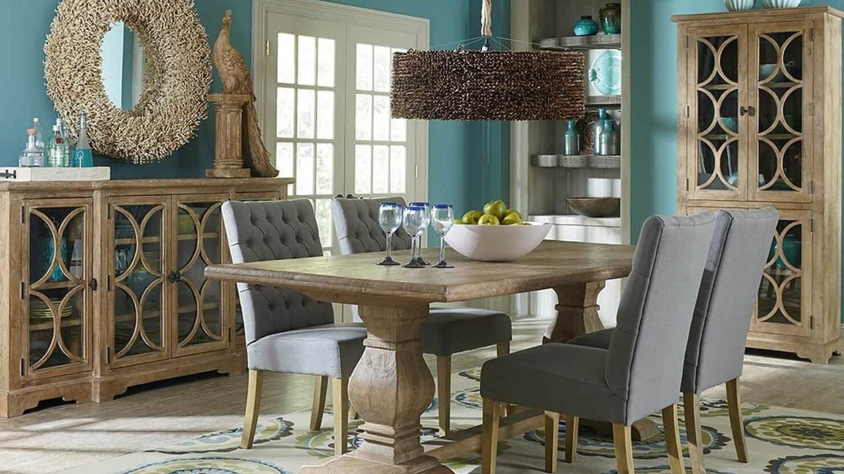 Rectangular farmhouse dining table styled with upholstered chairs, cabinets and a pendant light