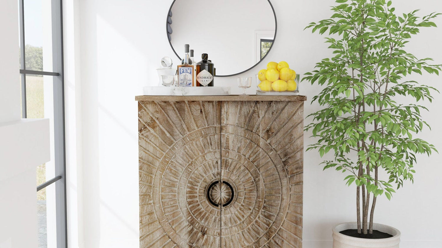 Home bar cabinet styled with barware, mirror, and greenery