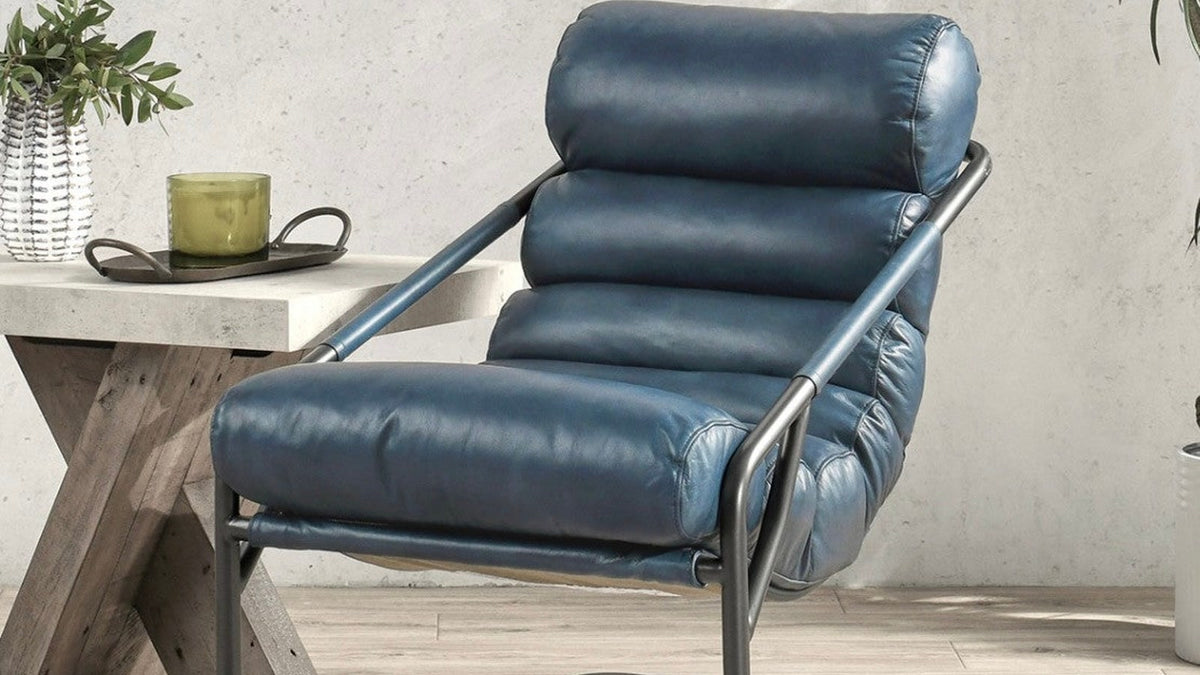 Blue leather accent chair with channel tufting styled beside a side table and floor lamp