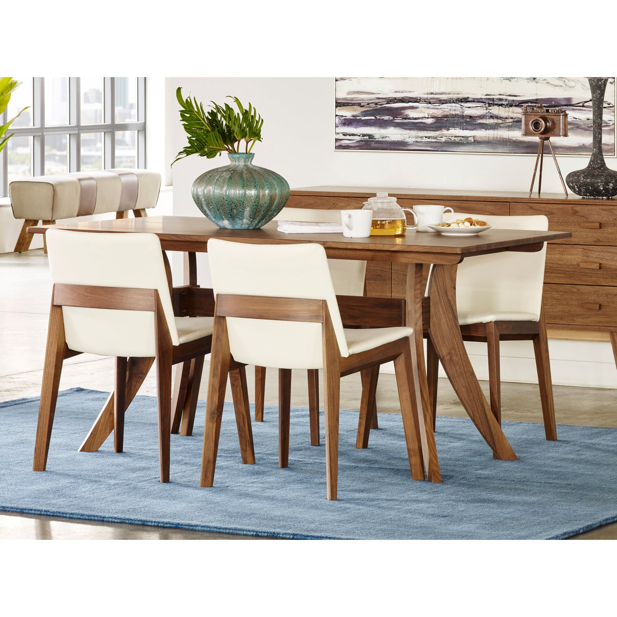 Moe's Florence wood dining table with light upholstered chairs, a matching sideboard, and a blue rug