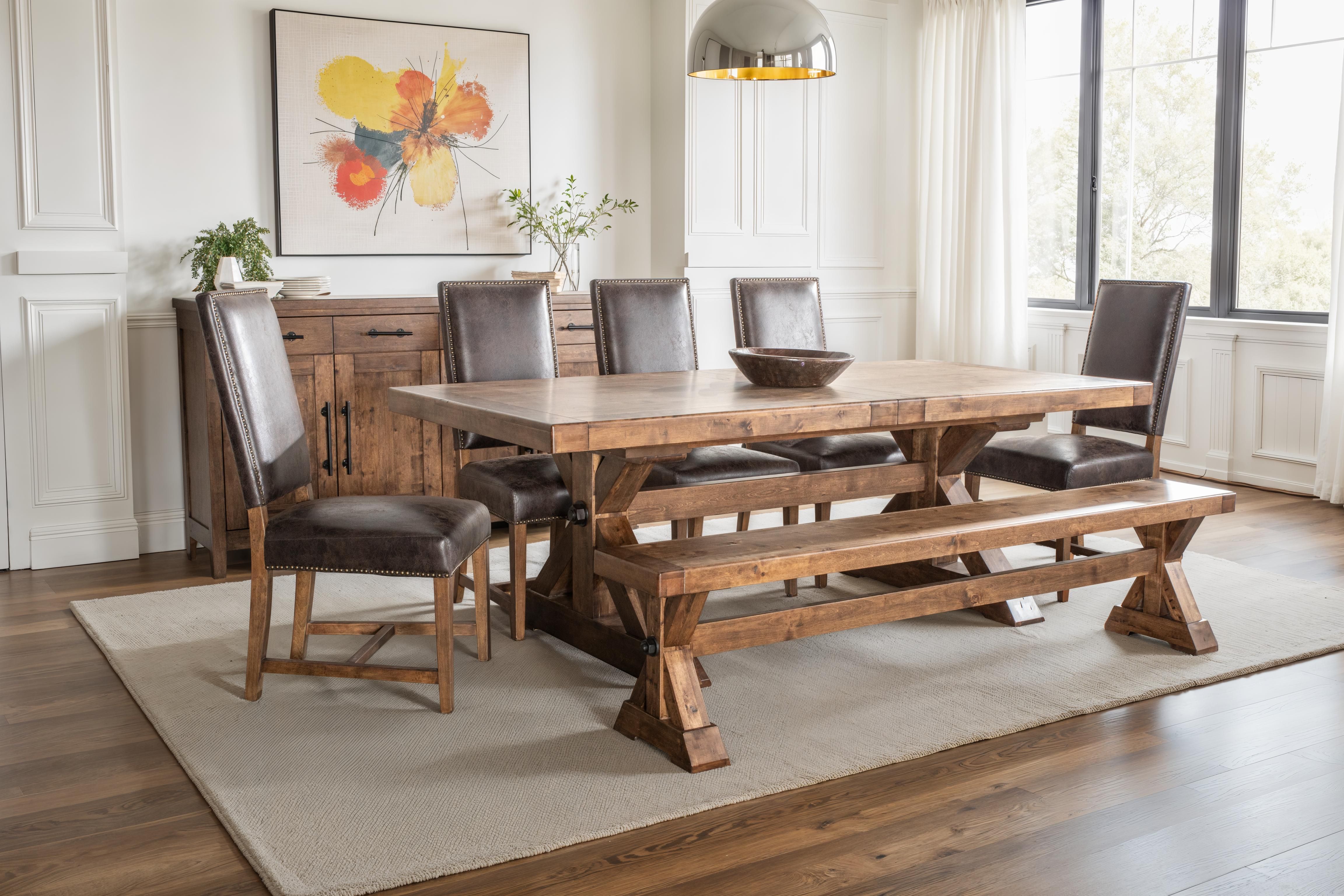 Dining room with wooden table, chairs, and bench on a rug.