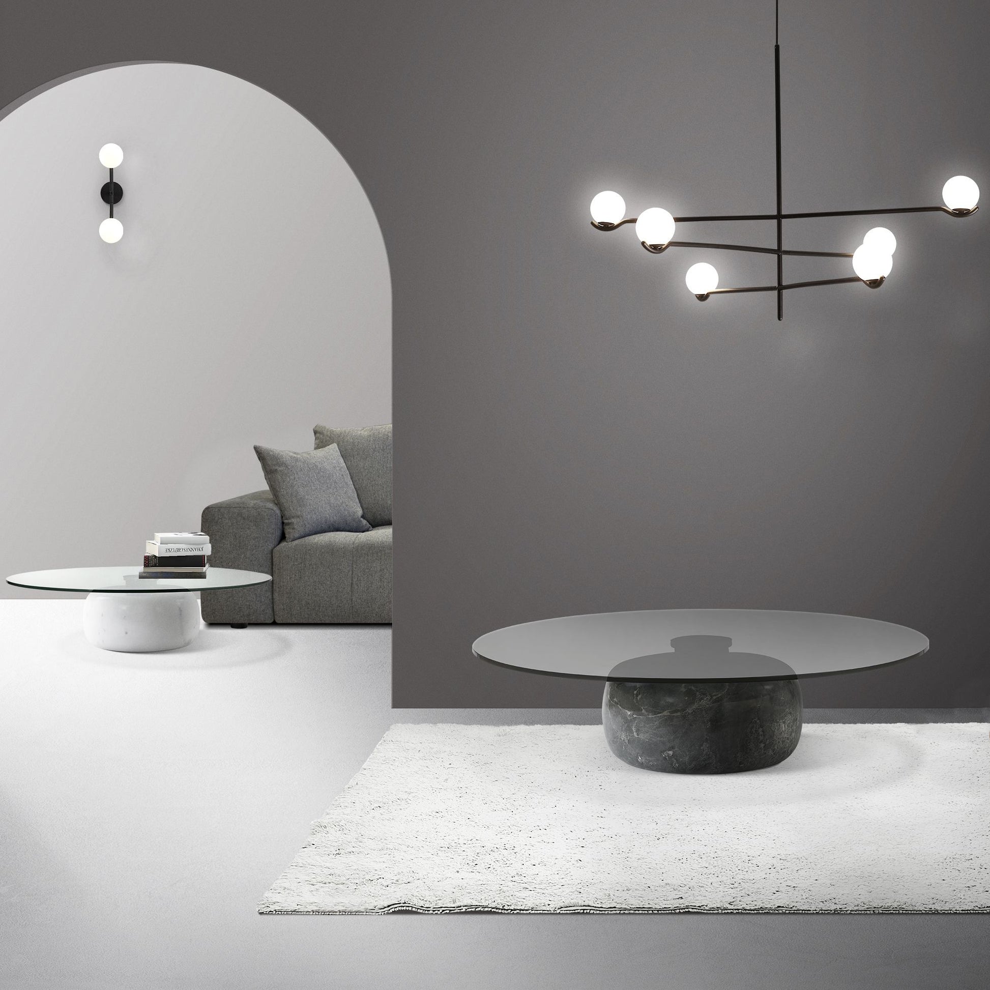 Modern living room with gray sofa, round marble table, and stylish chandelier.